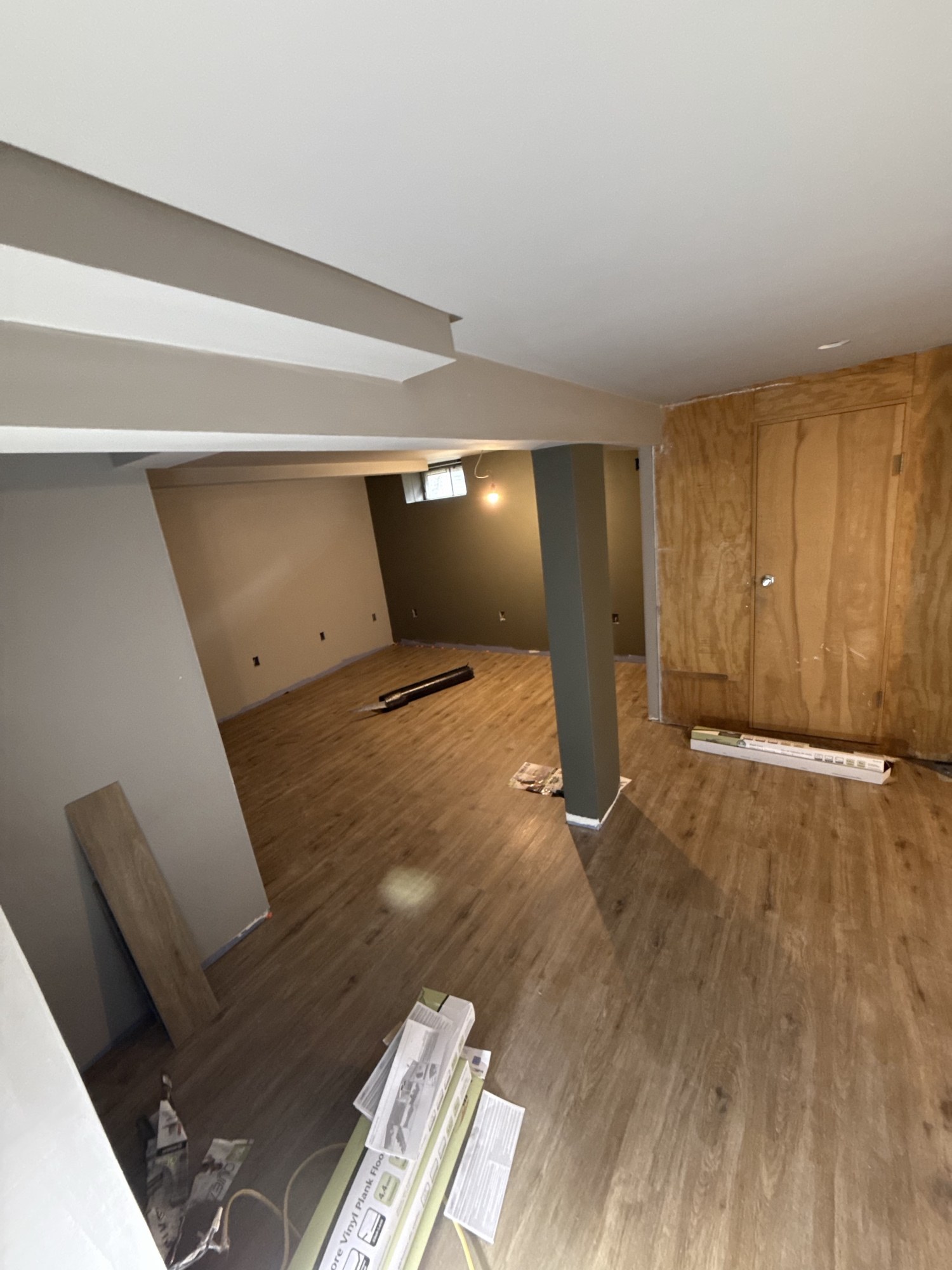 Same basement room finished with vinyl plank flooring and painted walls