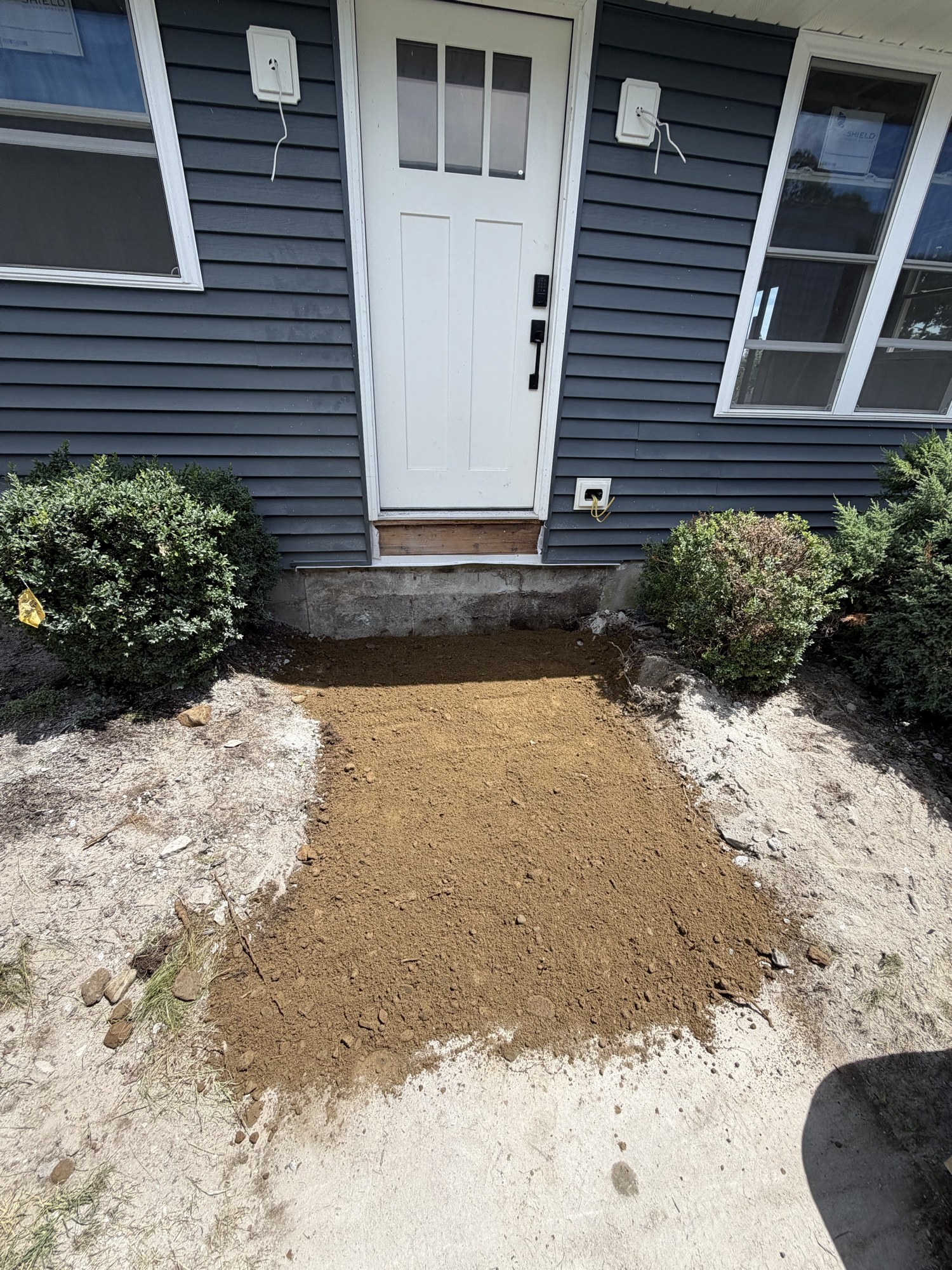 Front entry regraded with fresh soil after the old steps were removed