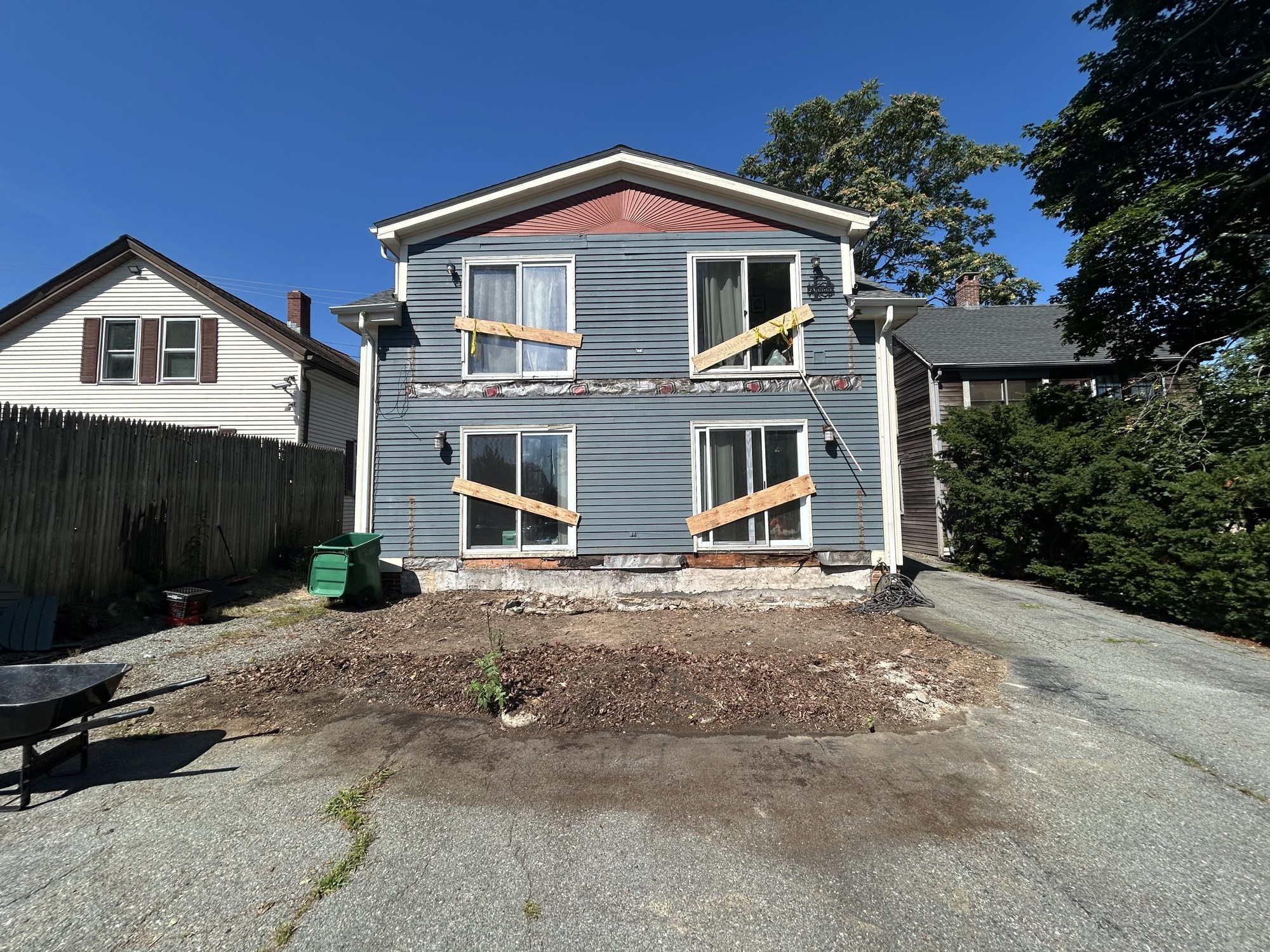 Rear exterior with the deck removed and siding stripped for repair