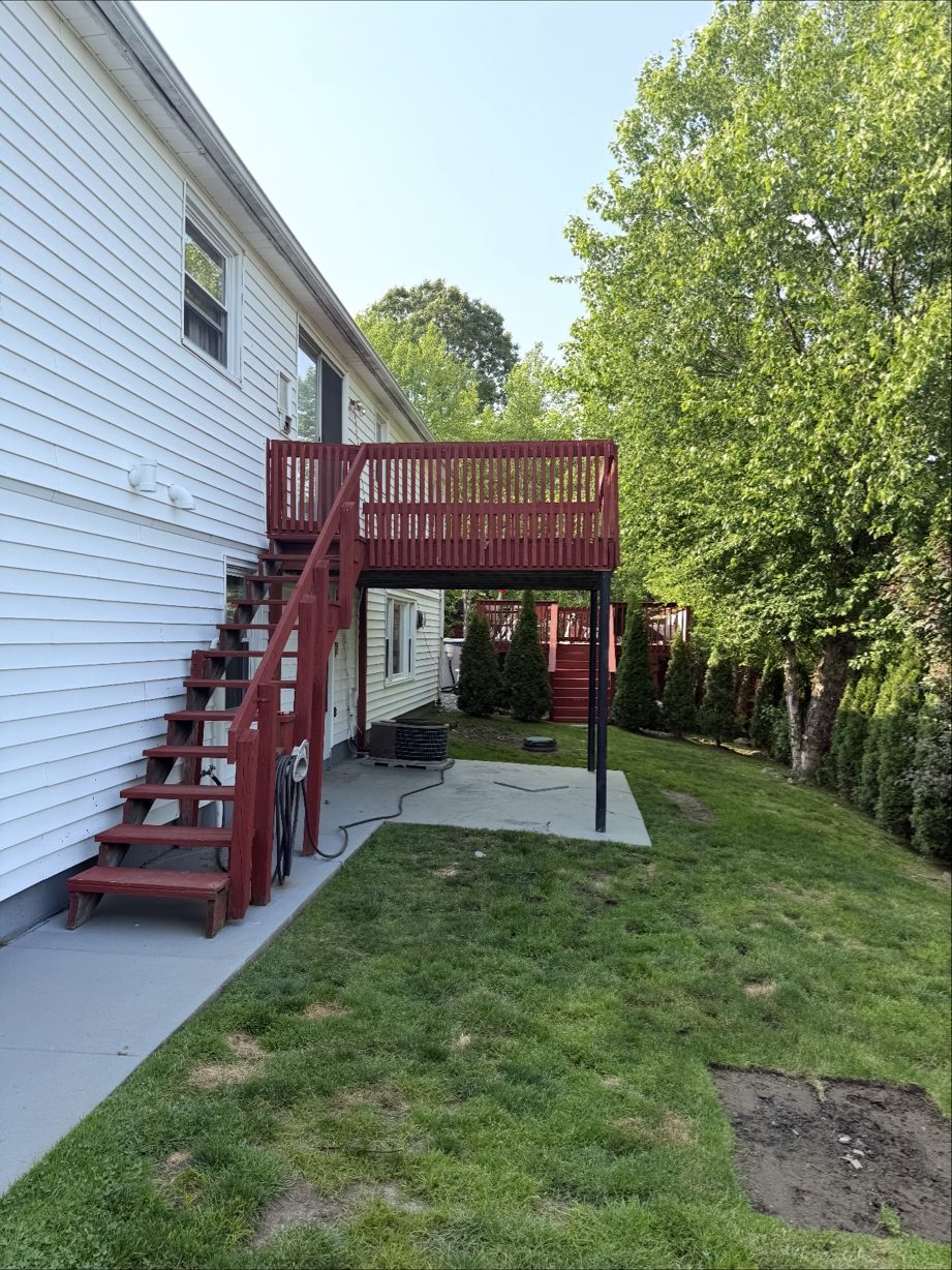 Original red-painted second-story deck and stairs before rebuild